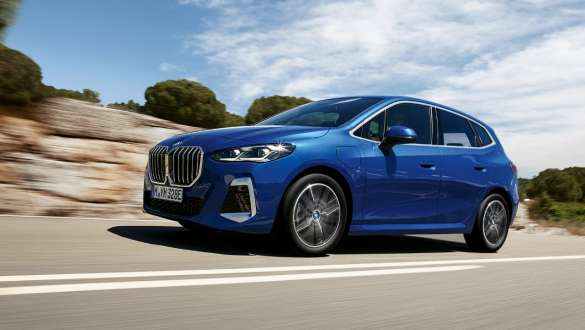 Плагин-гибрид BMW 2 Series Active Tourer 230e U06 2021 M в цвете Portimao Blue металлик, вид сбоку в три четверти, в движении по проселочной дороге
