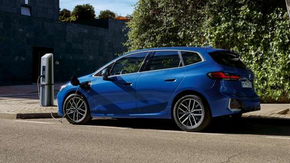 BMW 2 серии Active Tourer 230e плагин-гибрид U06 2021 M в цвете Portimao Blue металлик припаркован на зарядной станции, вид сбоку