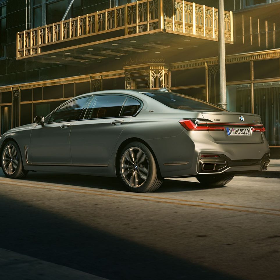 BMW M760Li xDrive с двигателем V12 BMW M760Li xDrive: вид сзади сбоку на фоне городских небоскребов