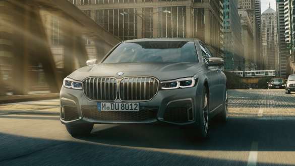 BMW M760Li xDrive Седан G11 G12 2019 в цвете Frozen Dark Silver metallic, вид на три четверти спереди в городских условиях, система Executive Drive Pro BMW M760Li xDrive Седан G11 G12 2019 в цвете Frozen Dark Silver metallic, вид на три четверти спереди в городских условиях, система Executive Drive Pro