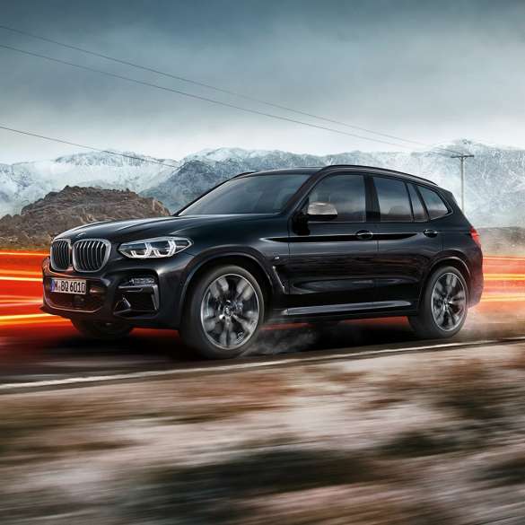 BMW X3 M40i and BMW X3 M40d, side view. BMW X3 M40i and BMW X3 M40d in Black Sapphire metallic, driving, exterior, side view in front of mountain scenery with light strips.