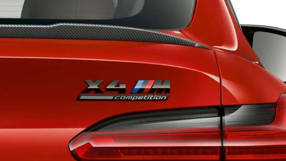 BMW X4 M Competition, задняя часть с надписью «X4 M Competition». BMW X4 M Competition в Toronto Red металлик, экстерьер, вид сзади крупным планом с задним спойлером из карбона и обозначением «X4 M Competition».