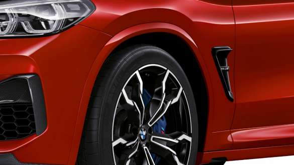 BMW X4 M Competition, боковой вид сзади крупным планом. BMW X4 M Competition в Toronto Red металлик, экстерьер, боковой вид сзади крупным планом, подвеска М.