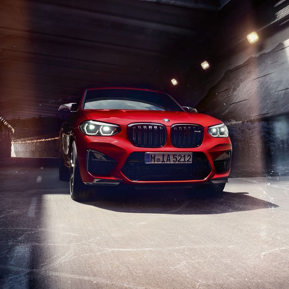BMW X4 M Competition, вид спереди с поворотом в три четверти. BMW X4 M Competition в Toronto Red металлик, экстерьер, вид спереди с поворотом в три четверти.