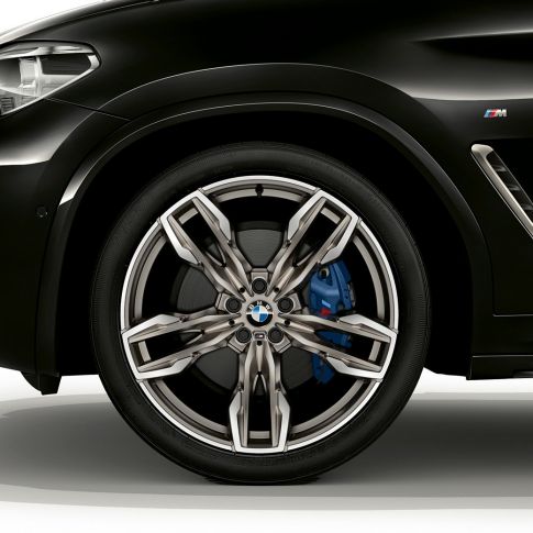 BMW X4 M40i и BMW X4 M40d, 21-дюймовые легкосплавные диски M. BMW X4 M40i и BMW X4 M40d в Black Sapphire металлик, экстерьер, вид сбоку с 21-дюймовыми легкосплавными колесными дисками M с двойными спицами.