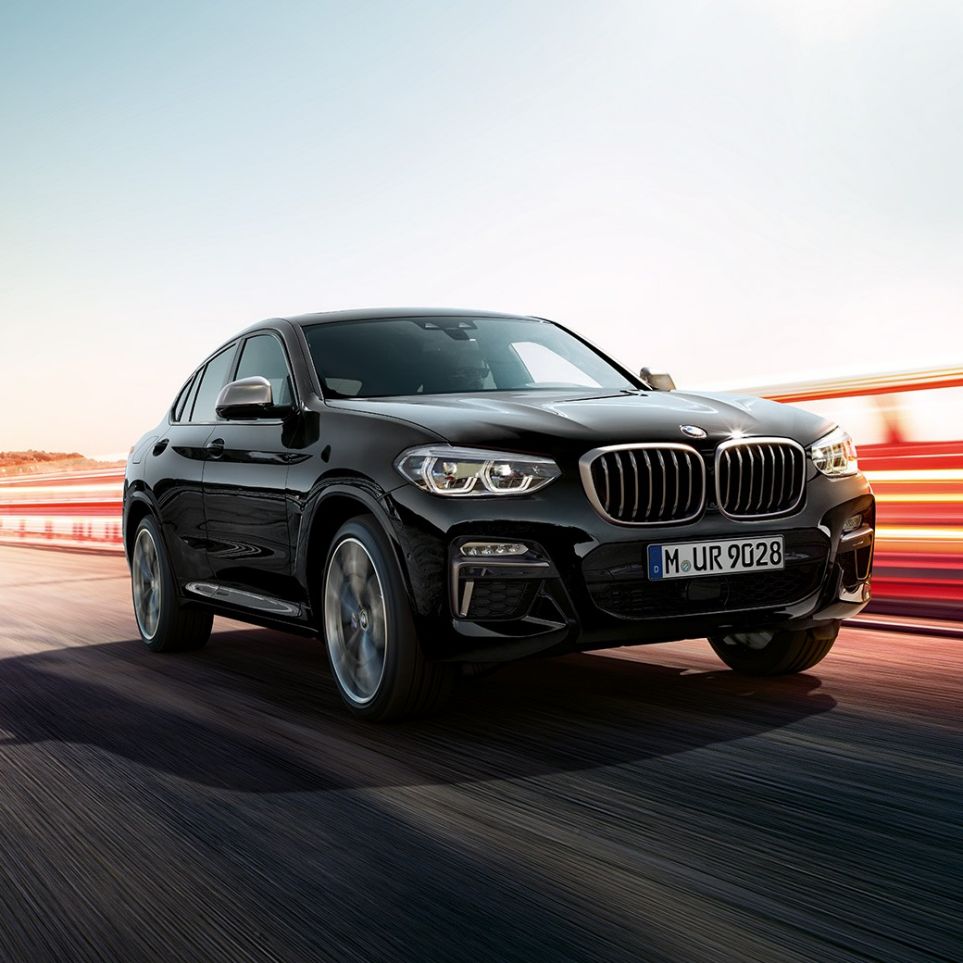 BMW X4 M40i и BMW X4 M40d, вид спереди с поворотом в три четверти. BMW X4 M40i и BMW X4 M40d в Black Sapphire металлик, экстерьер, вид спереди с поворотом в три четверти, левая сторона со световыми полосками.