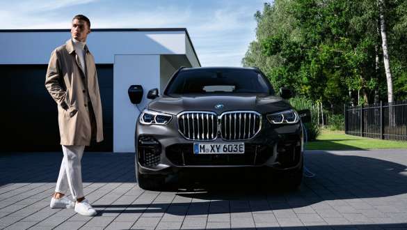 Плагин-гибрид BMW X5 xDrive45e G05, вид спереди перед гаражом Плагин-гибрид BMW X5 xDrive45e G05, вид машины спереди перед гаражом с моделью