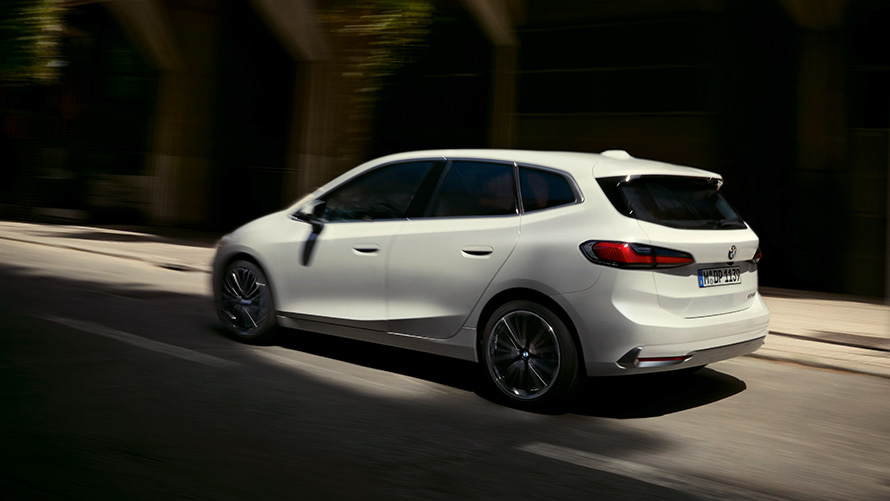 BMW 2 серии Active Tourer U06 2021 в цвете Mineral White металлик в движении на улице, вид сбоку