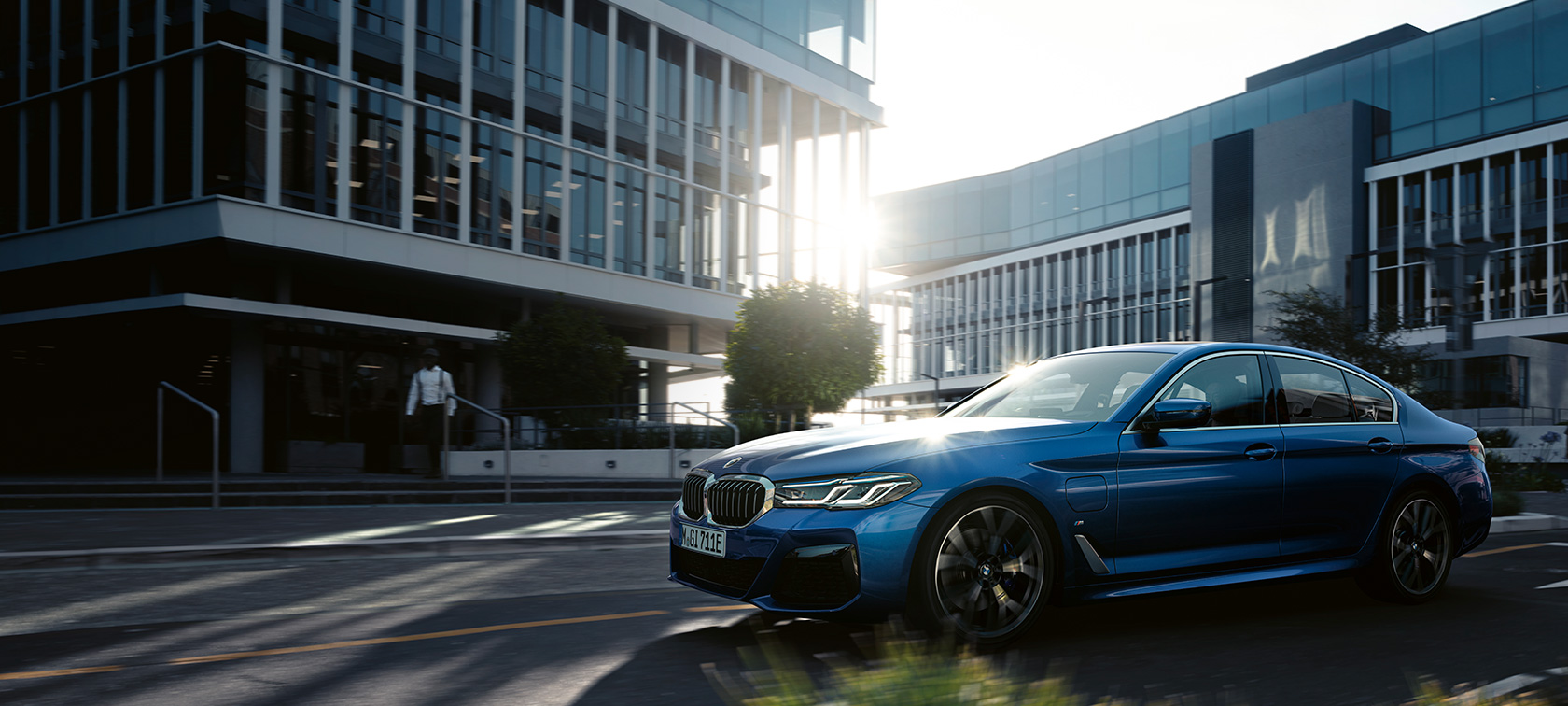 BMW 5 серии G30 в движении BMW 5 серии G30 (рестайлинг 2020 года), цвет «Синий Фитоник», в движении, вид спереди с поворотом в три четверти
