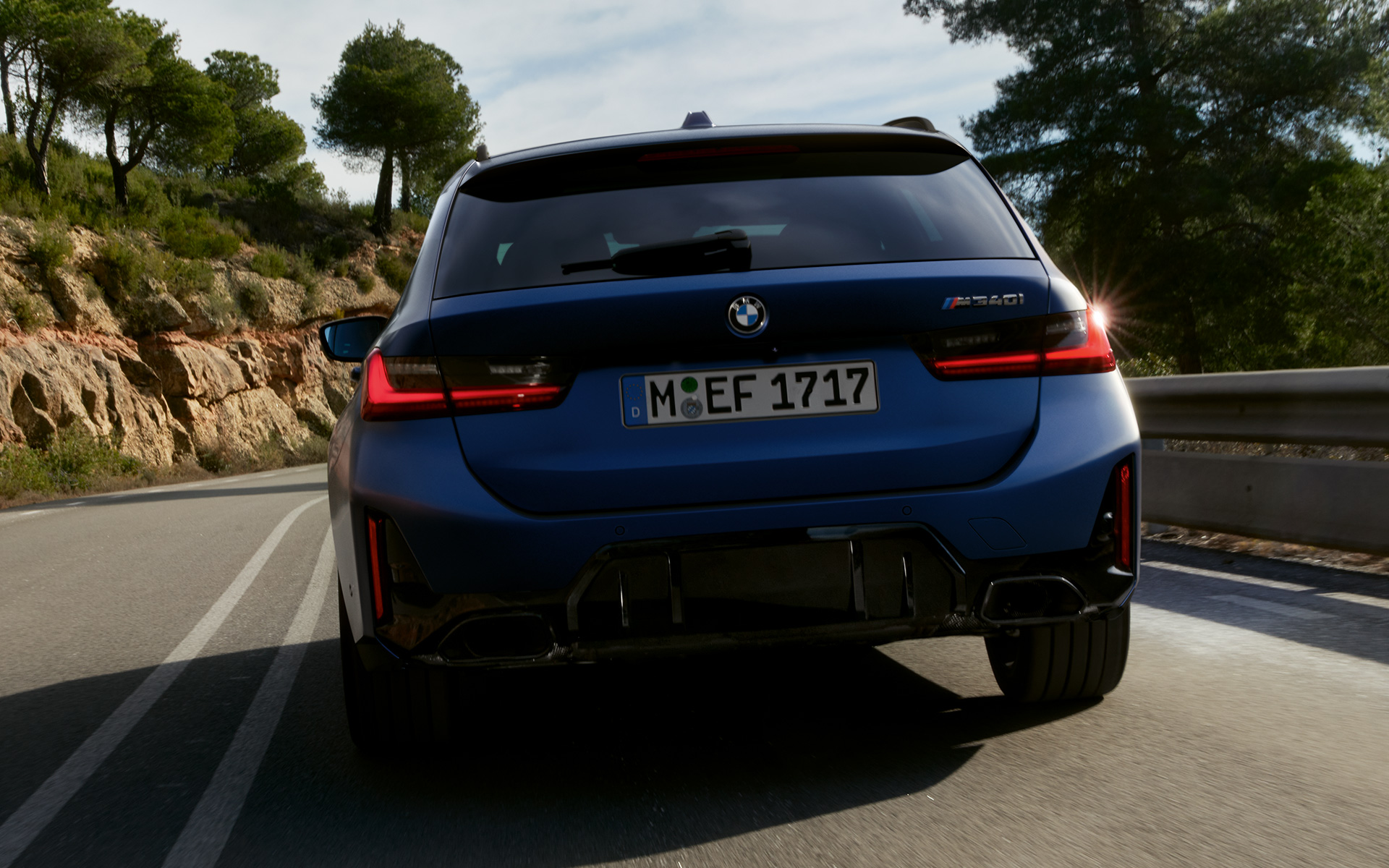 BMW M340i xDrive Touring G21, вид сзади в движении на улице BMW M340i xDrive Touring G21 в цвете Frozen Tanzanite Blue, вид сзади в движении на улице