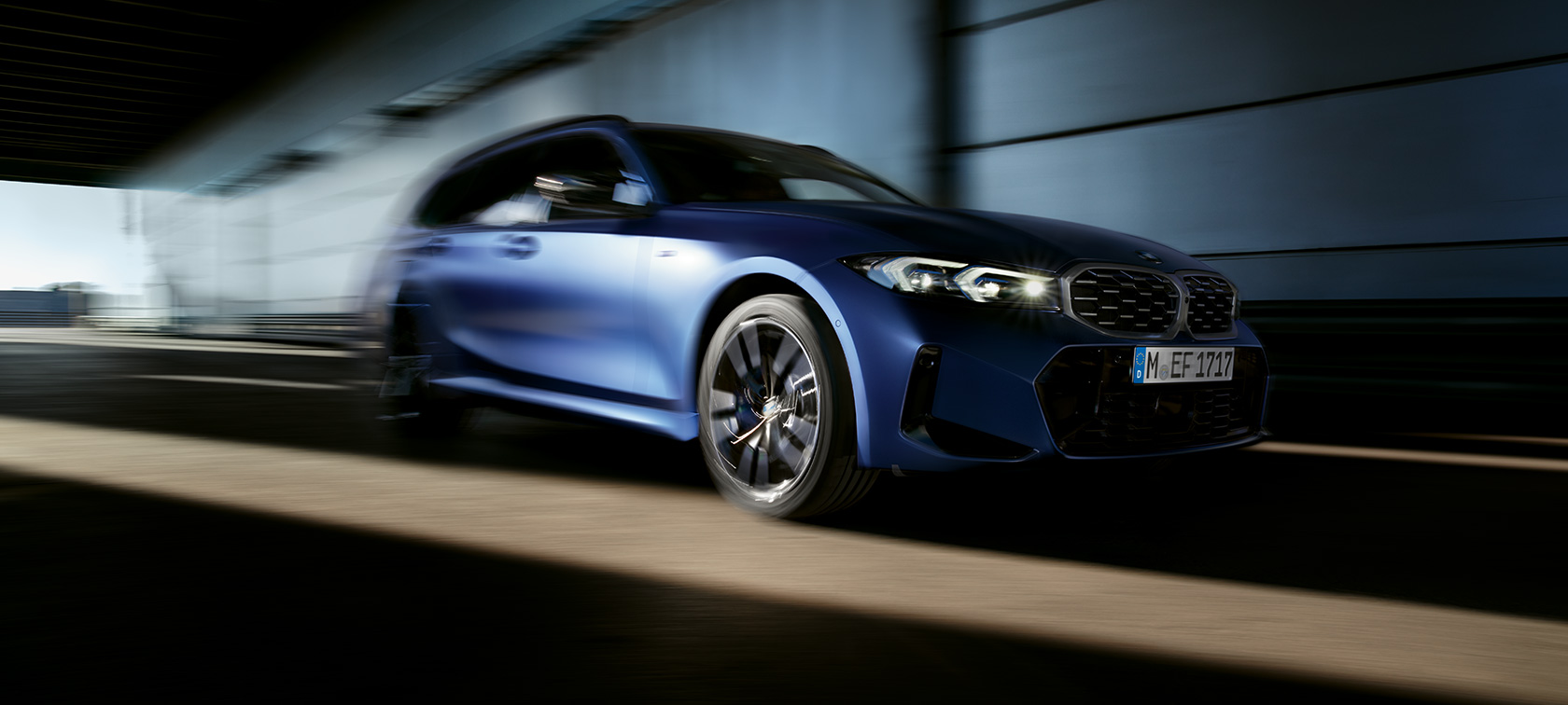BMW M340i xDrive Touring G21, вид сбоку в три четверти в движении BMW M340i xDrive Touring G21 в цвете Frozen Tanzanite Blue, вид сбоку в три четверти в движении