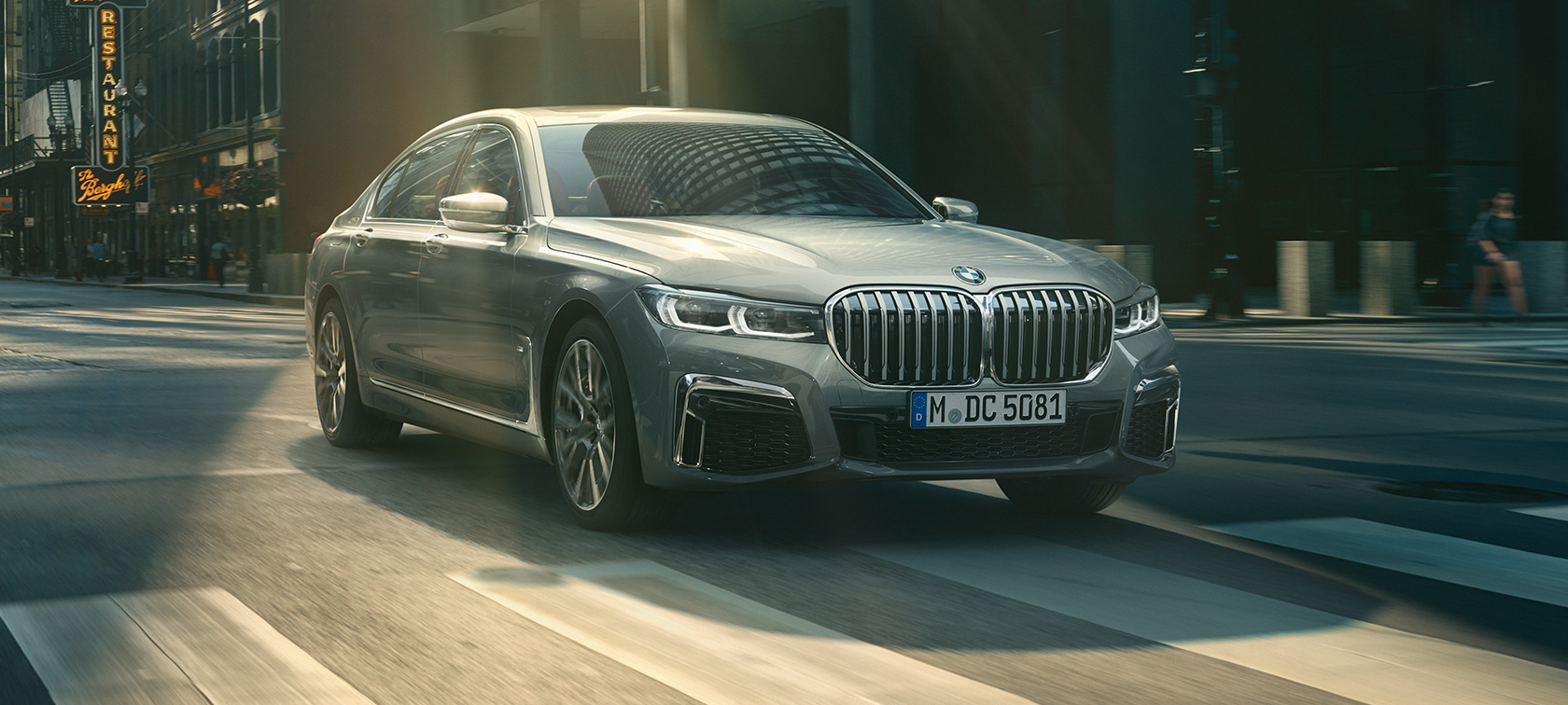 BMW M760Li xDrive Седан G11 G12 2019 в цвете Frozen Dark Silver metallic, вид на три четверти сзади в городских условиях. BMW M760Li xDrive Седан G11 G12 2019 в цвете Frozen Dark Silver metallic, вид на три четверти сзади в городских условиях.