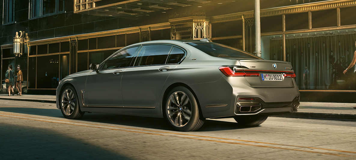 BMW M760Li xDrive Седан G11 G12 2019 в цвете Frozen Dark Silver metallic, вид на три четверти сбоку, езда в городских условиях BMW M760Li xDrive Седан G11 G12 2019 в цвете Frozen Dark Silver metallic, вид на три четверти сбоку, езда в городских условиях