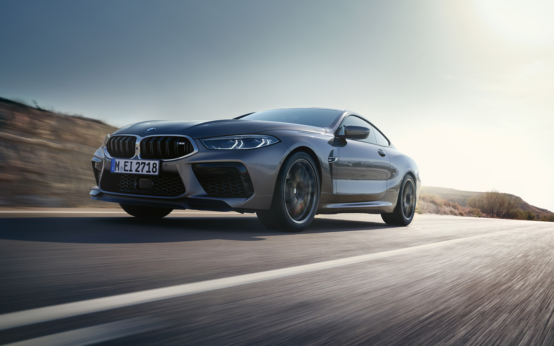 Вид спереди с поворотом в три четверти BMW M8 Coupé F92 LCI (рестайлинг 2022 года) в движении на магистрали BMW M8 Coupé F92 LCI (рестайлинг 2022 года) Серый Графит металлик, вид спереди снизу с поворотом в три четверти, в движении на магистрали