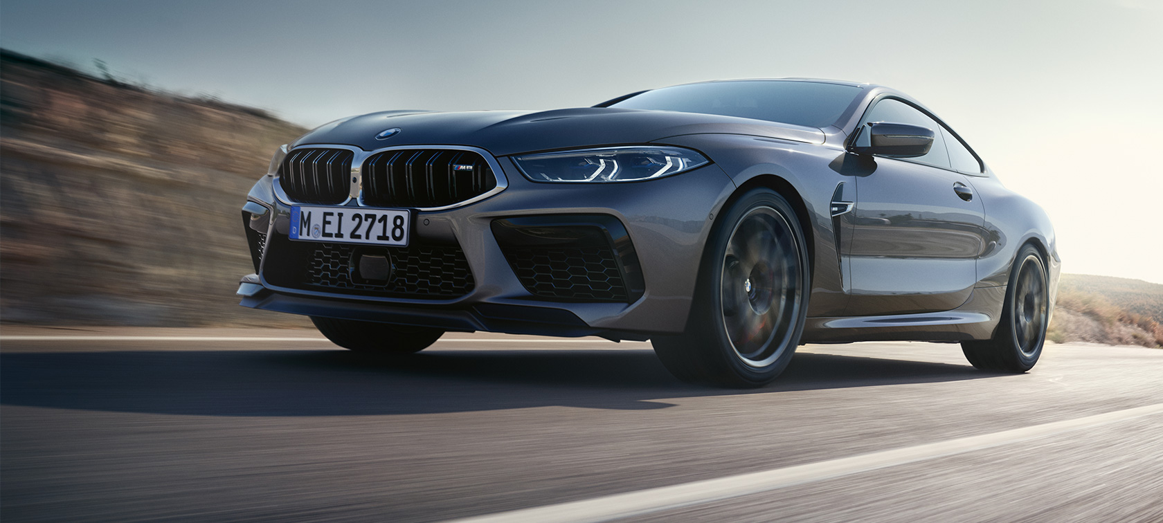 BMW M8 Coupé F92 LCI (рестайлинг 2022 года) вид сбоку с поворотом в три четверти, в движении BMW M8 Coupé F92 LCI (рестайлинг 2022 года) Серый Графит металлик, вид сбоку снизу с поворотом в три четверти