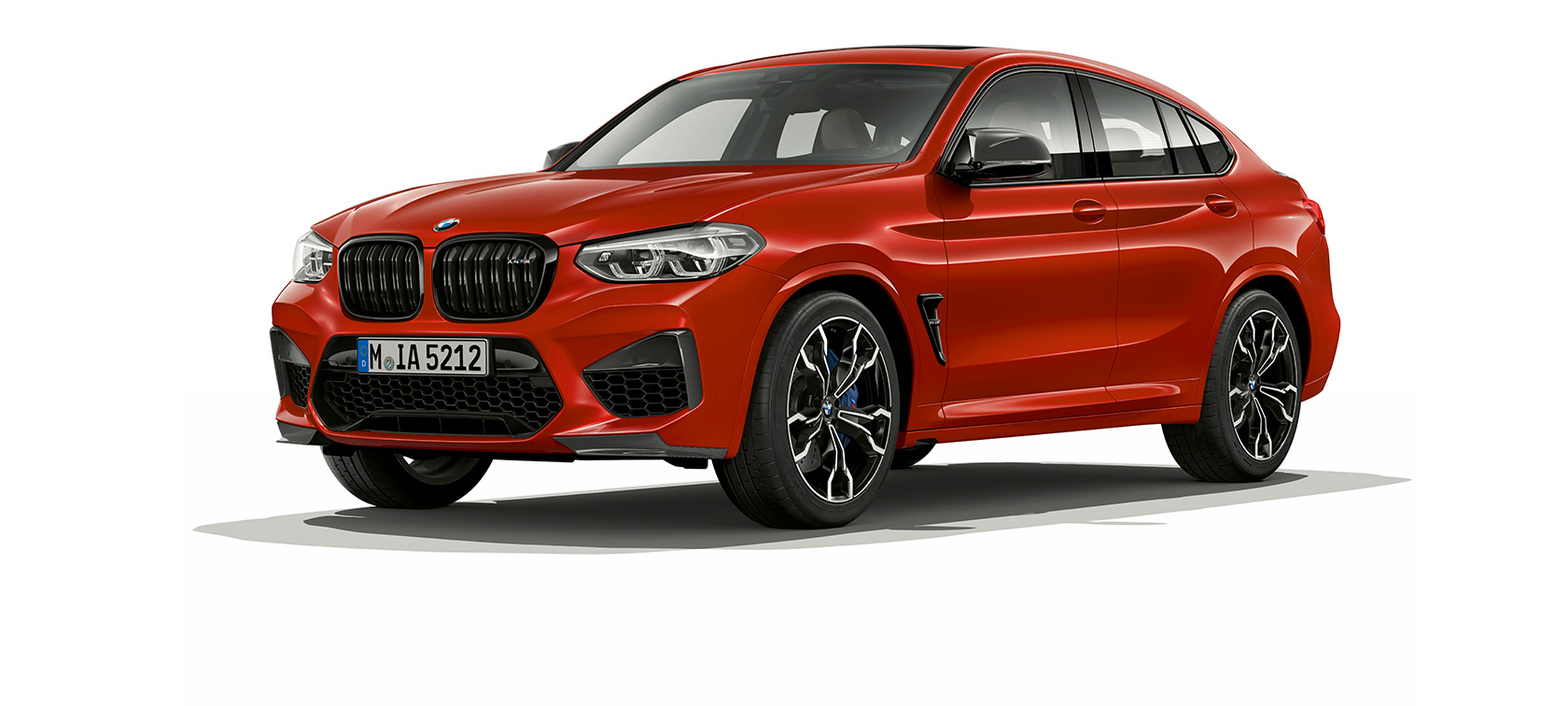 BMW X4 M Competition, вид cбоку с поворотом в три четверти. BMW X4 M Competition в Toronto Red металлик, экстерьер, вид сбоку с поворотом в три четверти.