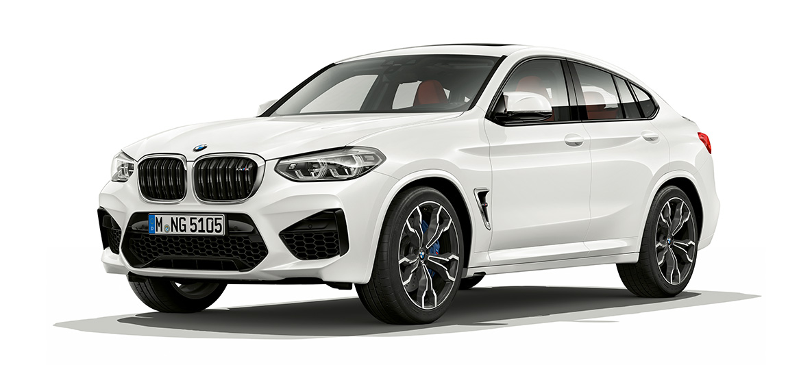 BMW X4 M, вид сбоку с поворотом в три четверти. BMW X4 M в Alpine White, экстерьер, вид сбоку с поворотом в три четверти.
