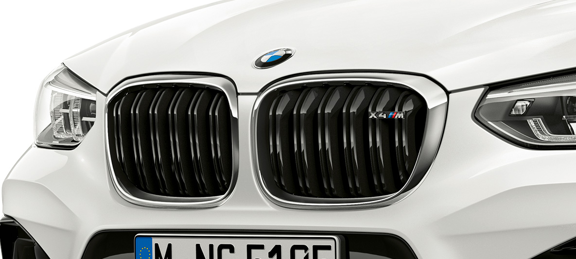 BMW X4 M, решетка радиатора М. BMW X4 M в Alpine White, экстерьер, передняя часть, решетка радиатора M с хромированными вставками и обозначением модели.