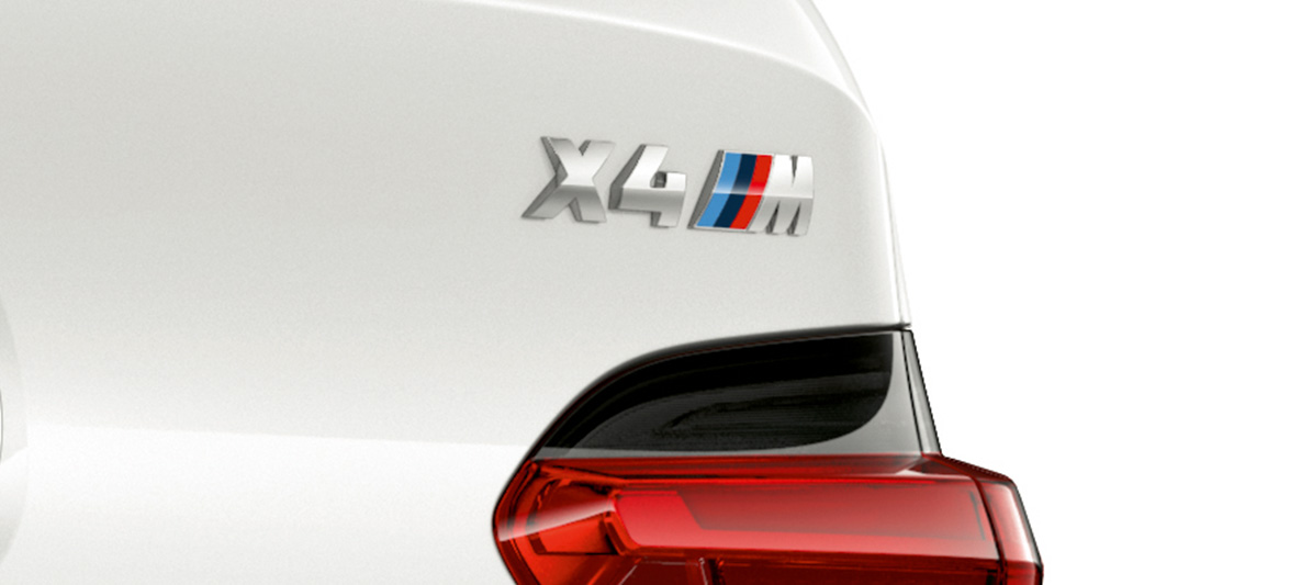 BMW X4 M, обозначение модели. BMW X4 M в Alpine White, экстерьер, задняя часть крупным планом с обозначением модели.