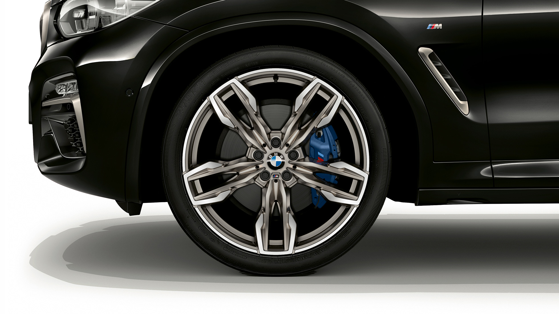 BMW X4 M40i и BMW X4 M40d, 21-дюймовые легкосплавные диски M. BMW X4 M40i и BMW X4 M40d в Black Sapphire металлик, экстерьер, вид сбоку с 21-дюймовыми легкосплавными колесными дисками M с двойными спицами.