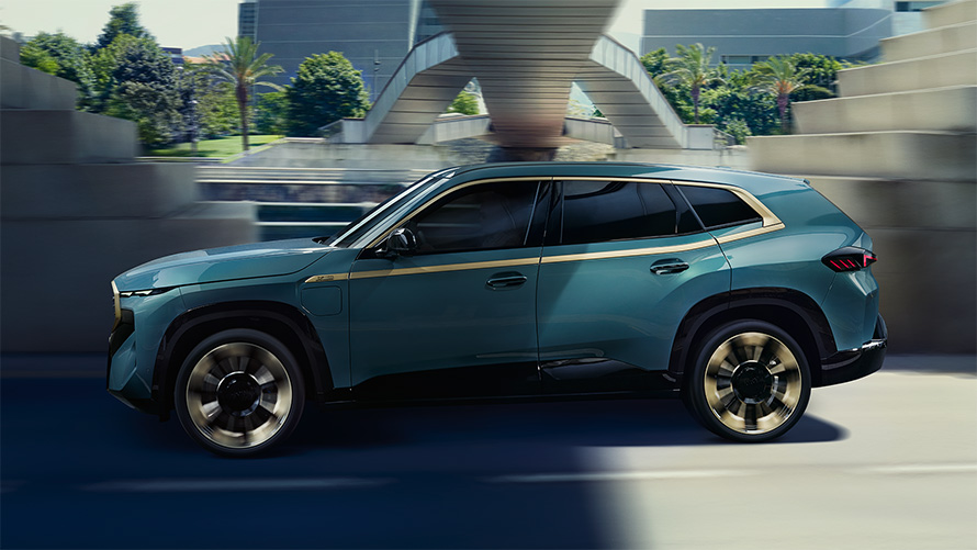 BMW XM G09, экстерьер, вид сбоку, в движении, акцентная линия цвета Night Gold