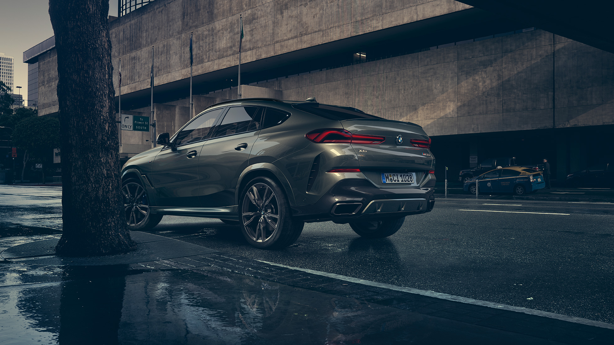 Экстерьер BMW X6. BMW X6, вид сзади с поворотом в три четверти плане перед городской обстановкой.