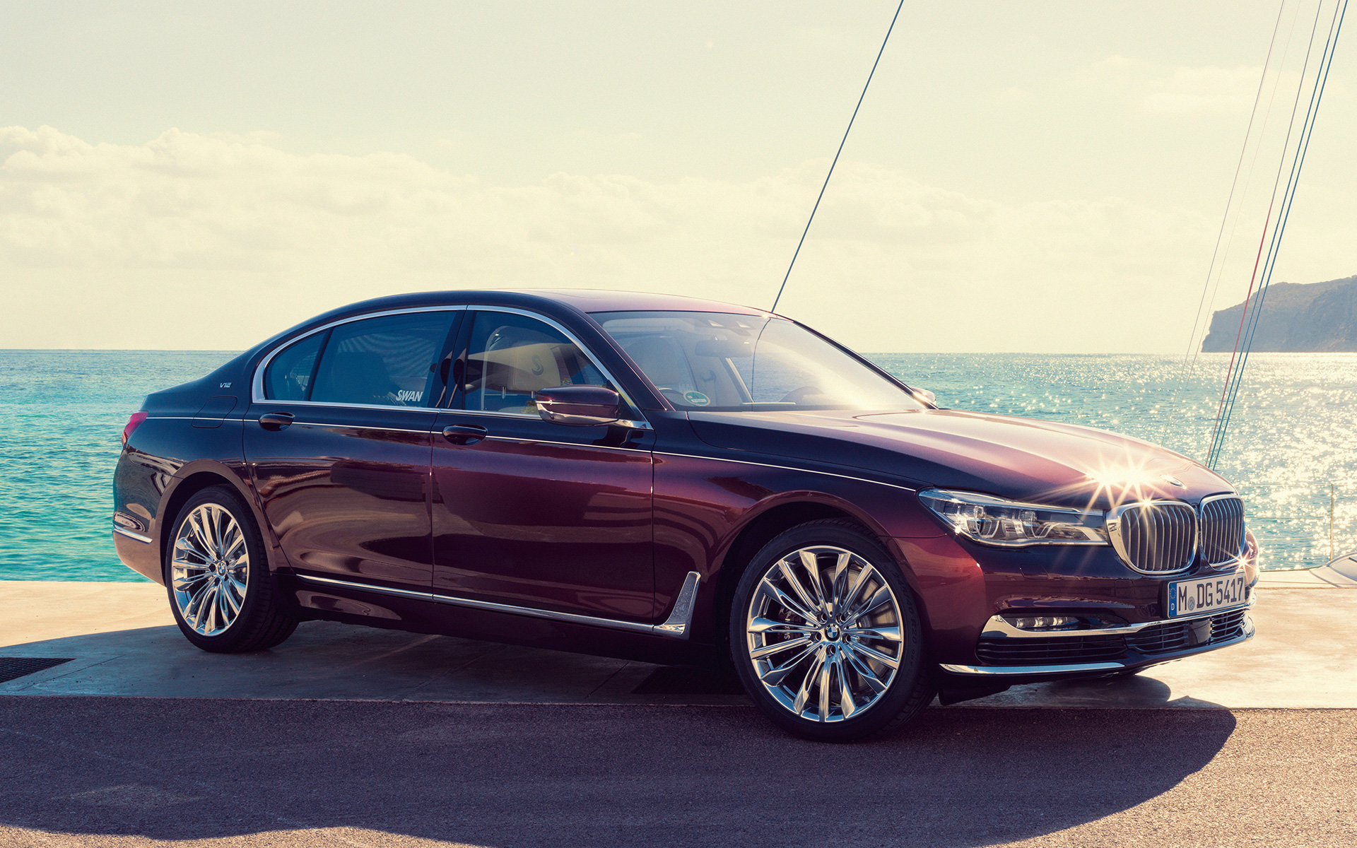 BMW M760Li xDrive Nautor’s Swan – BMW Individual G12 2017 перед яхтой BMW M760Li xDrive Nautor's Swan – BMW Individual G12 2017, вид сбоку в три четверти на пирсе перед яхтой в заливе